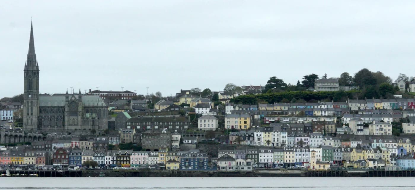 The tiered painted houses of Cobh rising from the harbour beneath the spire of St Colman's Cathedral