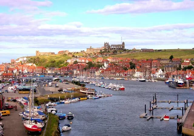 Whitby harbour and the River Esk, with the abbey ruin on the East Cliff above the red pantile roofs of the old town