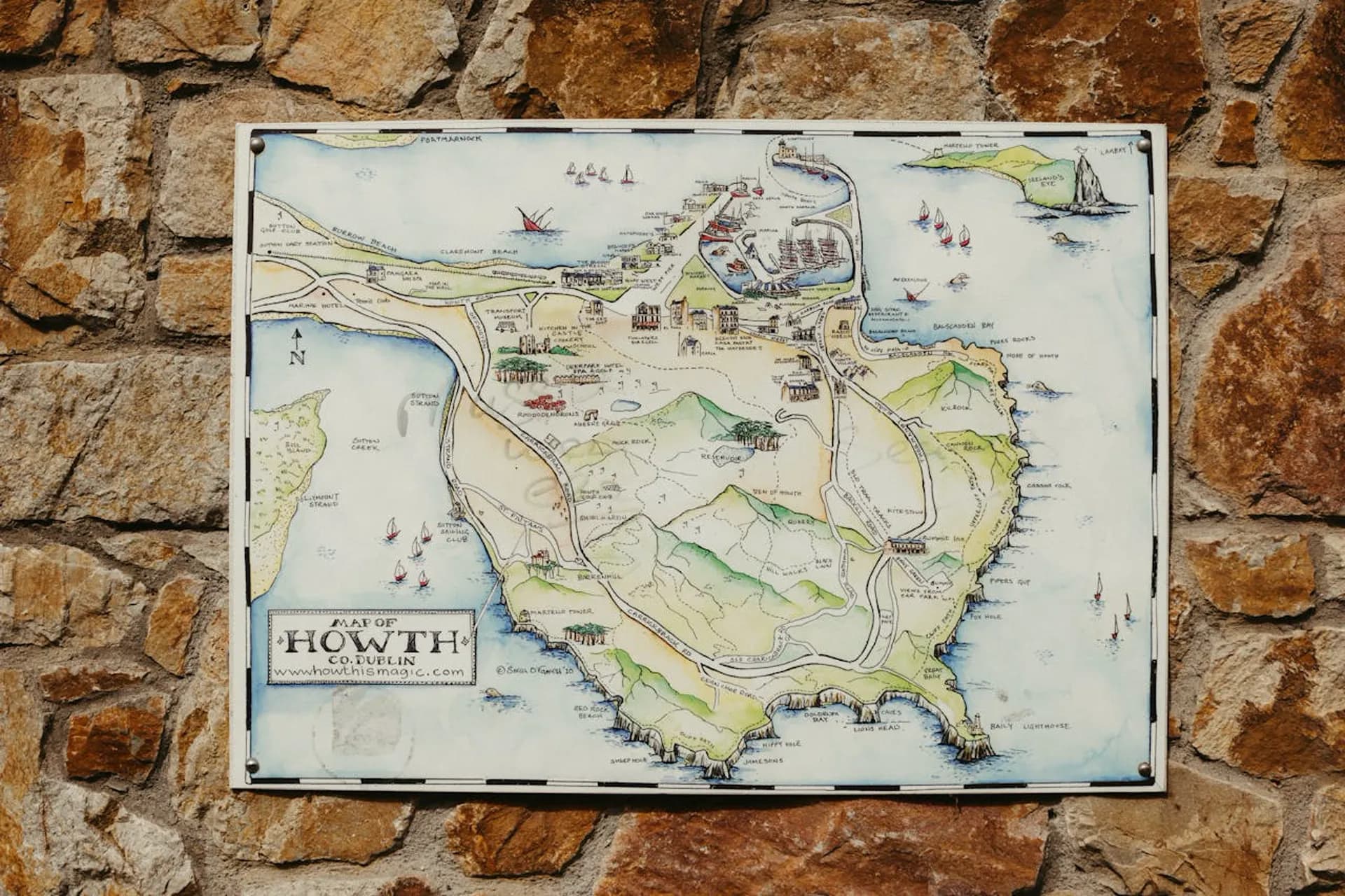 Explore Howth map mounted on a stone wall near the harbour