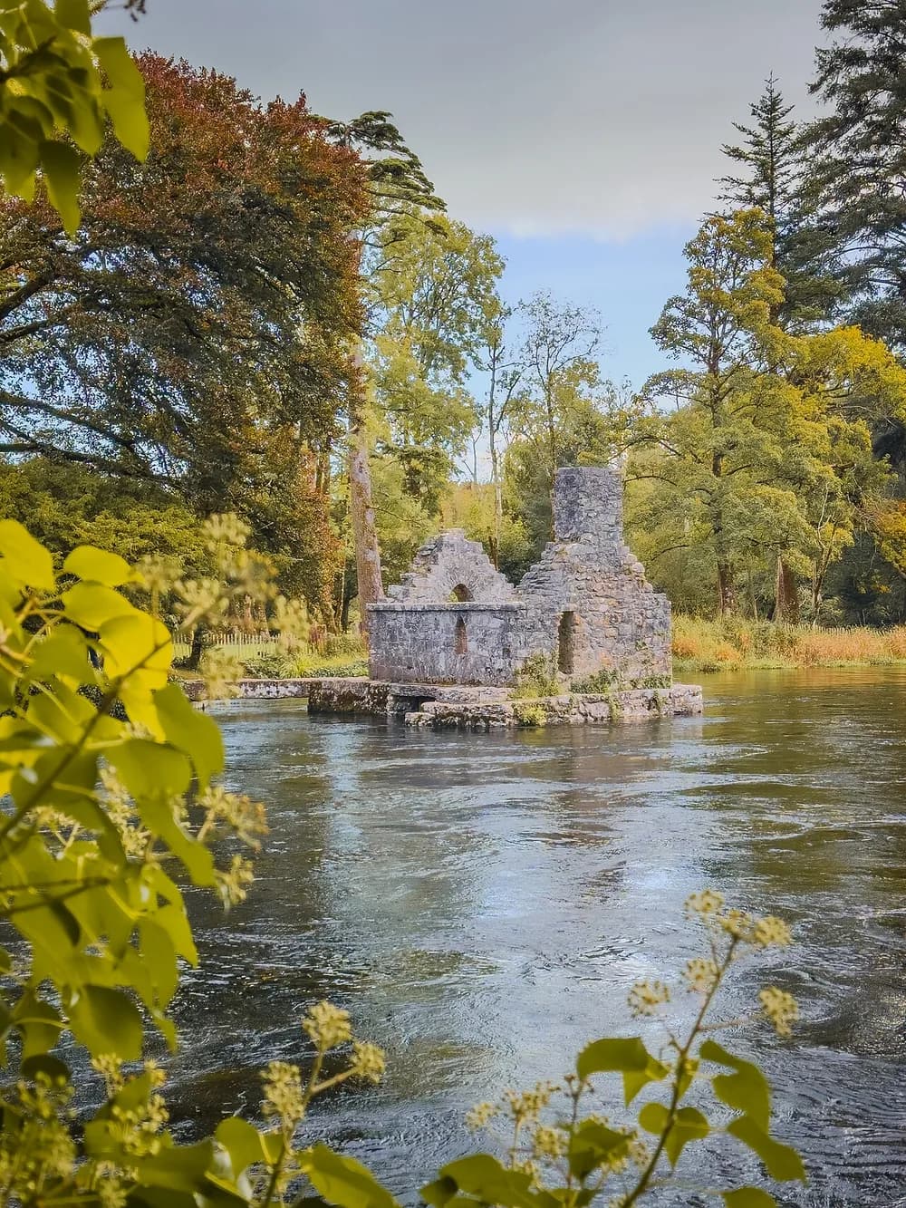 The roofless Monks' Fishing House standing on its stone pier in the Cong River