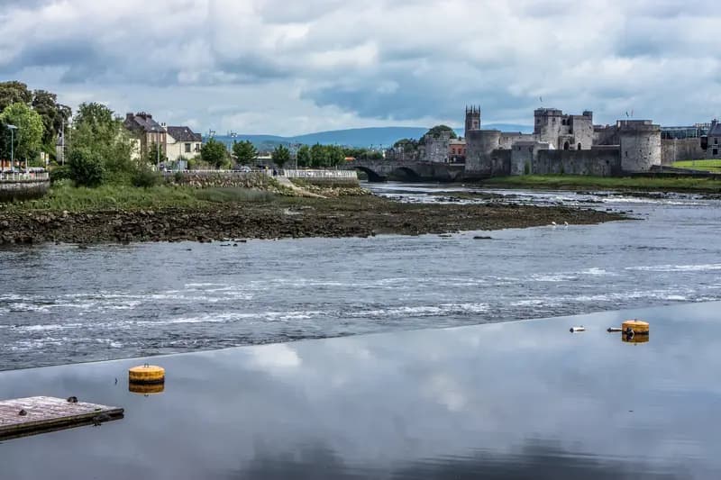 The tidal River Shannon flowing past King John's Castle and Thomond Bridge on King's Island in Limerick