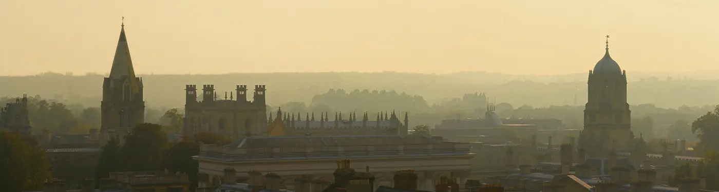 Oxford's skyline at dusk from the University Church tower, with Christ Church Cathedral's spire and Tom Tower