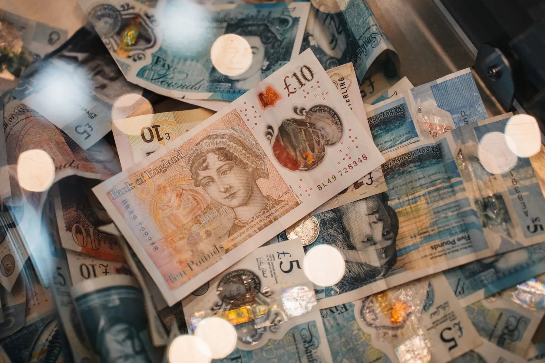 Bank of England ten and five pound notes lying across Royal Bank of Scotland and Bank of Scotland notes, showing how the Scottish designs differ
