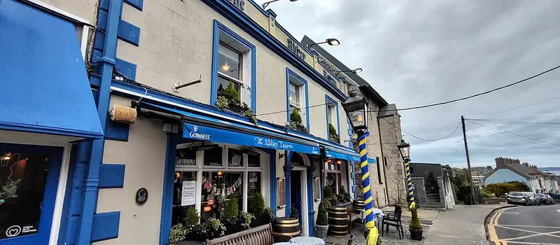 The Abbey Tavern in Howth, a traditional Irish pub painted blue with Guinness signage and lanterns
